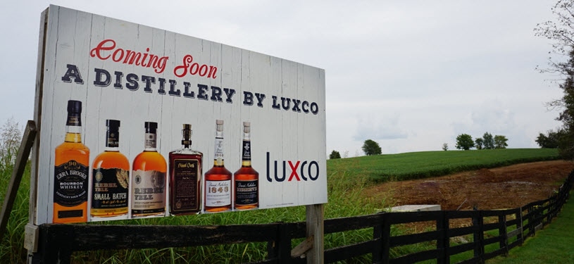 Lux Row Distillers - Sign at Entrance via Row of Trees