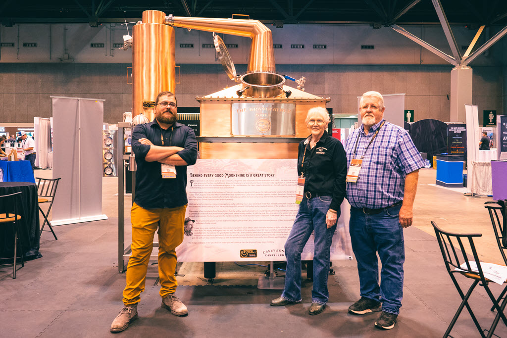 Casey Jones Distillery - Cody Turner, Peg Hays and Arlon 'AJ' Casey Jones in front of The Grandfather 150 Gallon Coffin Pot Still